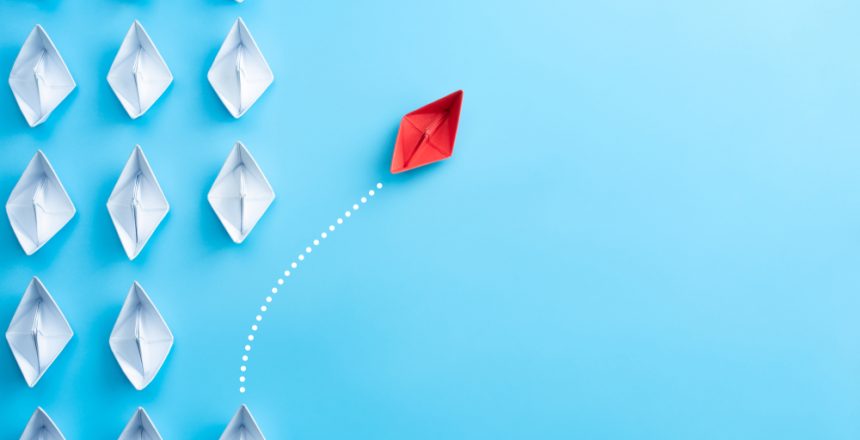 Barco vermelho saindo de perto dos barcos brancos